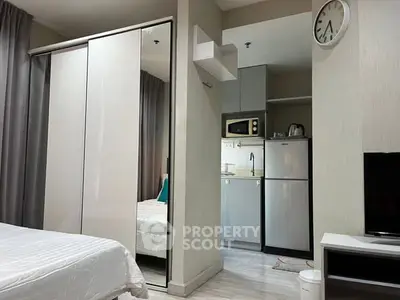 Modern studio apartment with sleek kitchen and cozy bedroom area.
