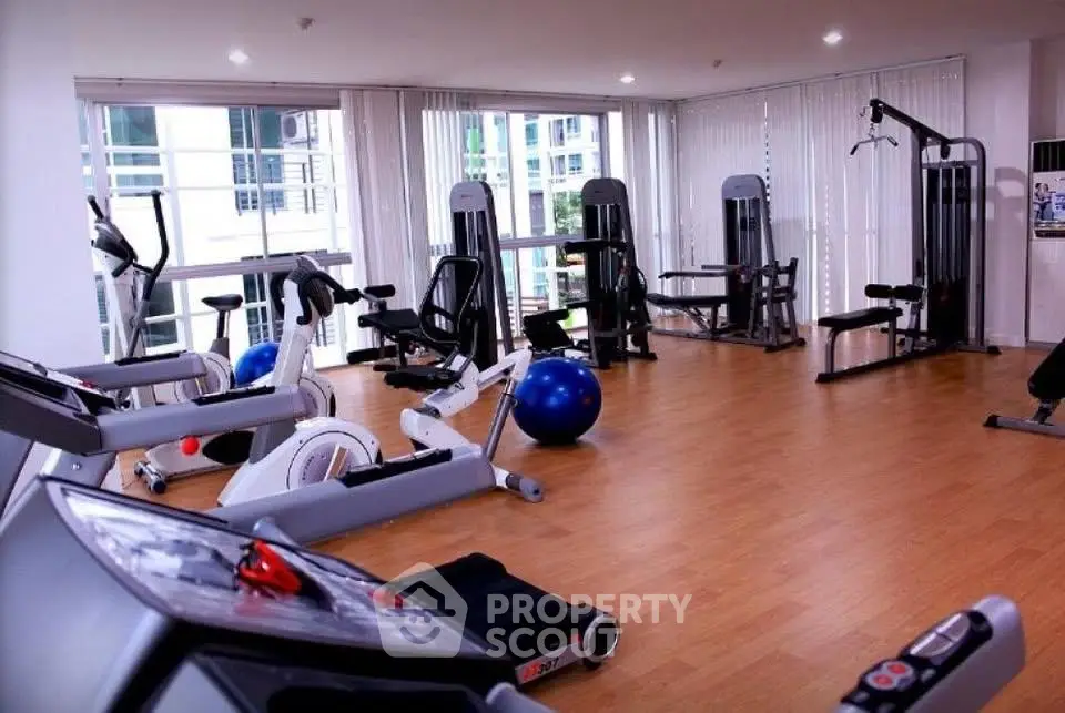 Modern gym with state-of-the-art fitness equipment and bright natural lighting.