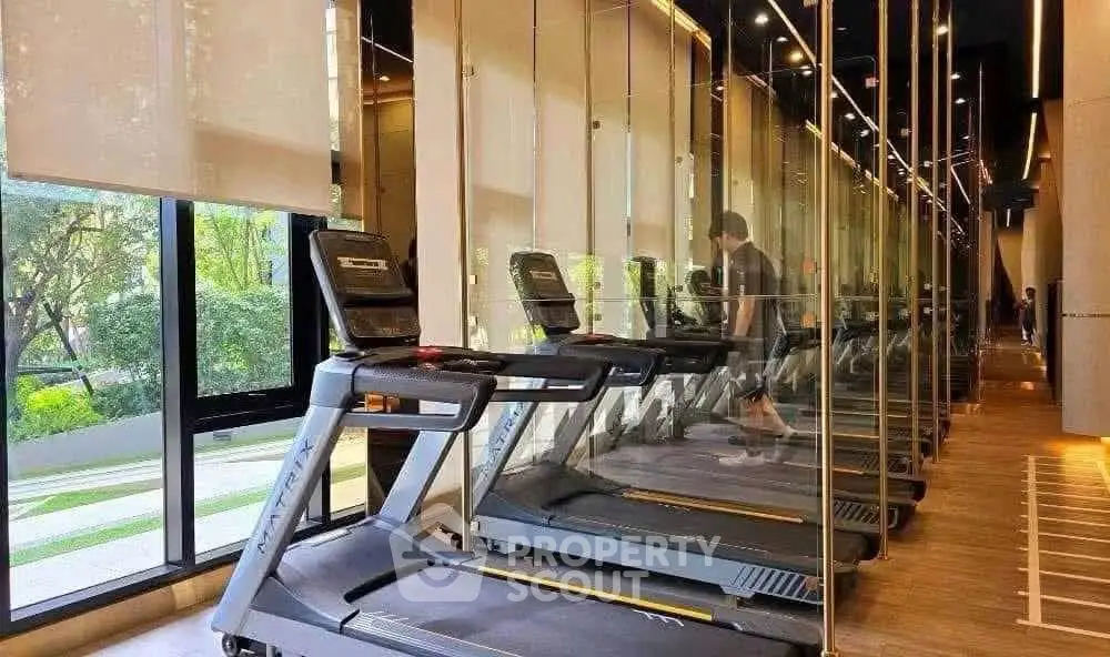 Modern gym with treadmills and large windows offering a scenic view, perfect for fitness enthusiasts.