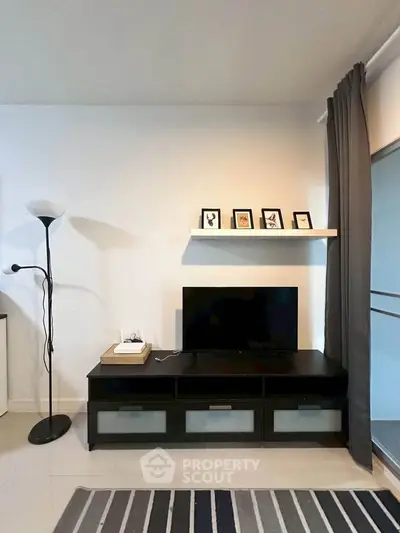 Modern living room with sleek TV stand, floor lamp, and decorative shelf.