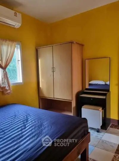 Cozy bedroom with vibrant yellow walls and natural light
