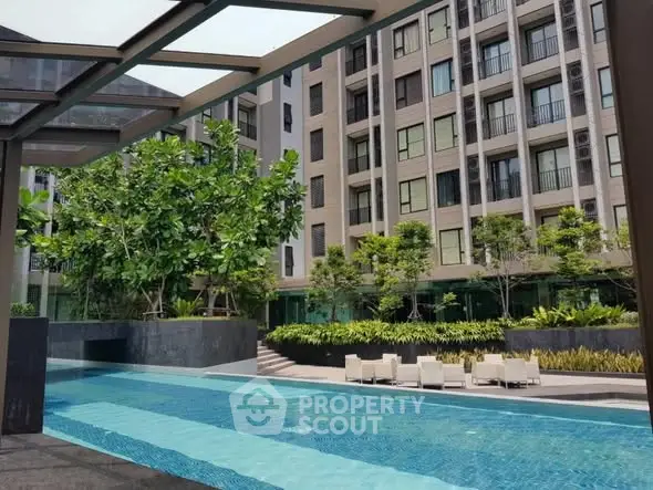 Luxurious apartment complex with stunning pool and lush greenery