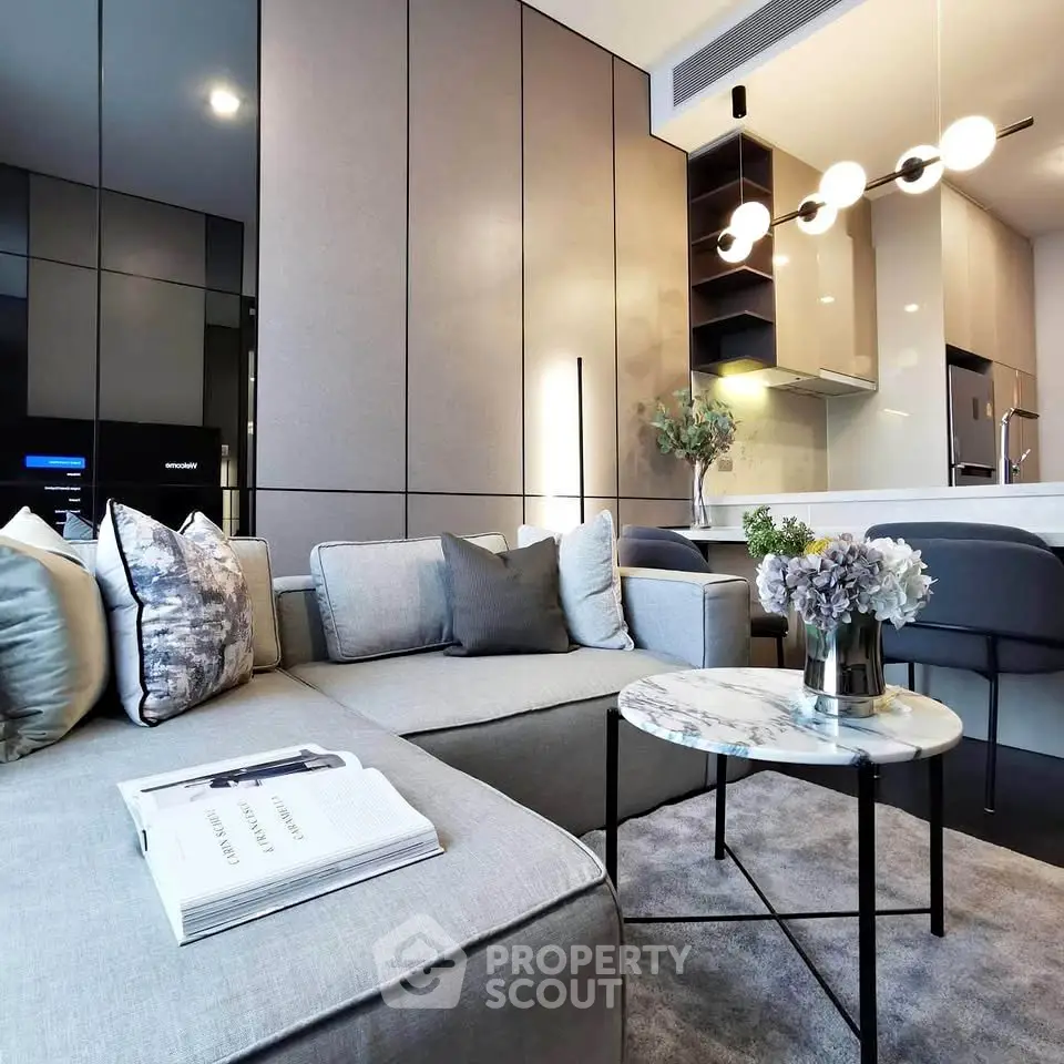 Modern living room with sleek design, featuring a cozy sofa, elegant lighting, and a stylish open kitchen.