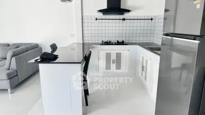 Modern open-layout kitchen with sleek appliances and stylish living area