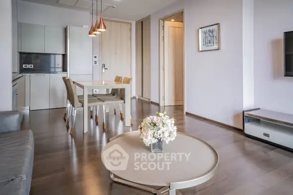 Modern living room with open kitchen, stylish decor, and elegant lighting in a contemporary apartment.