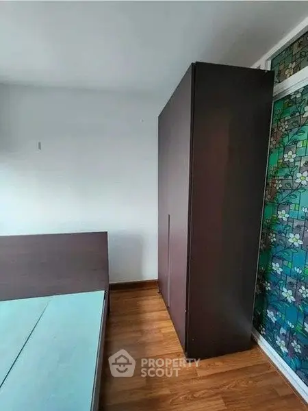 Spacious bedroom with wooden flooring and large wardrobe, ideal for modern living.