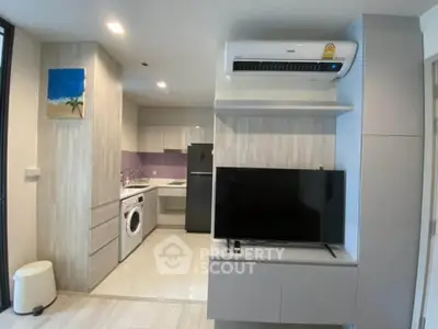 Modern apartment interior with open kitchen and living area featuring sleek appliances and stylish decor.