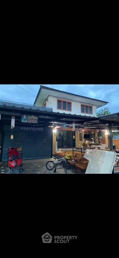 Charming two-story home with cozy outdoor seating and coffee shop ambiance.