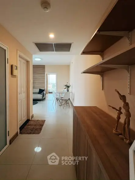 Modern apartment hallway leading to a cozy living area with stylish decor.