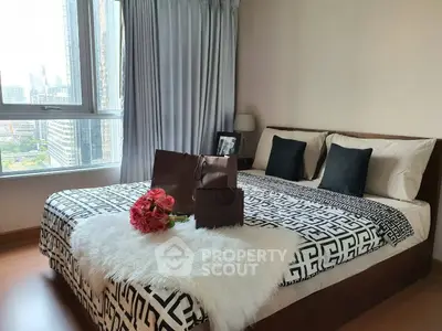 Luxurious bedroom with city view, elegant decor, and stylish bedding in modern apartment.
