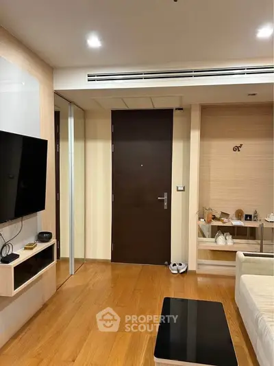 Modern living room with wooden flooring and sleek TV setup