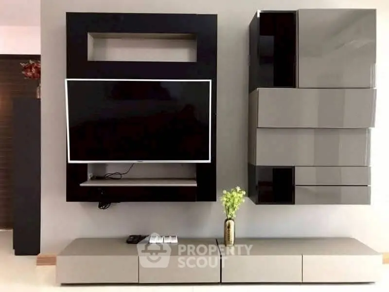 Modern living room with sleek wall-mounted TV and stylish storage units.
