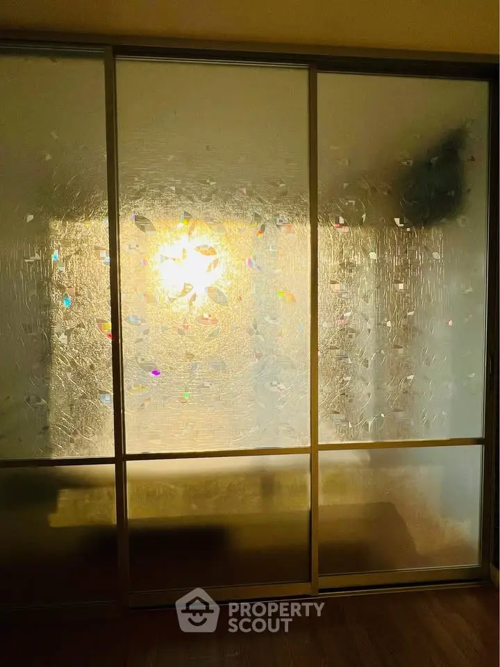 Elegant frosted glass sliding doors in a modern interior space with warm lighting.