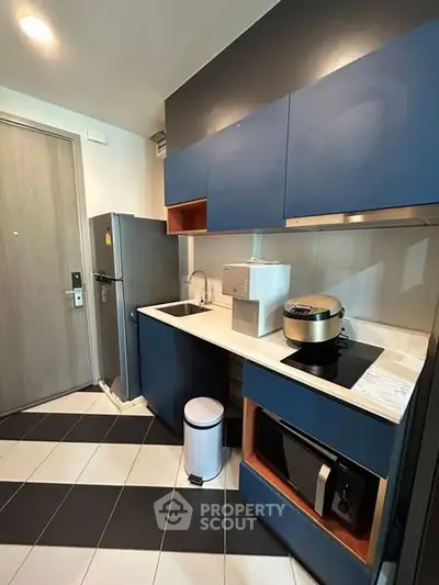 Modern kitchen with sleek blue cabinets and stylish appliances