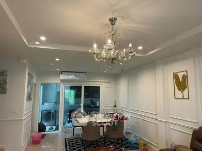 Elegant living room with chandelier and modern dining area