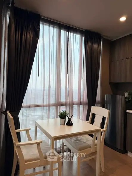 Modern dining area with large windows and elegant curtains in a stylish apartment.
