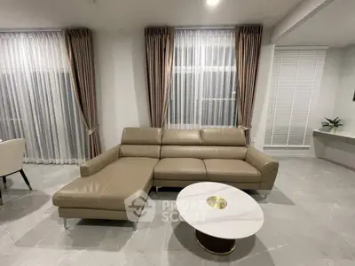 Elegant living room with modern leather sectional sofa and chic round coffee table.