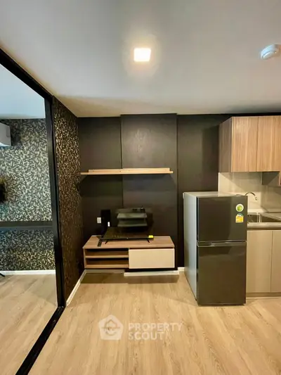 Modern kitchen with sleek design, featuring a compact fridge and stylish cabinetry.