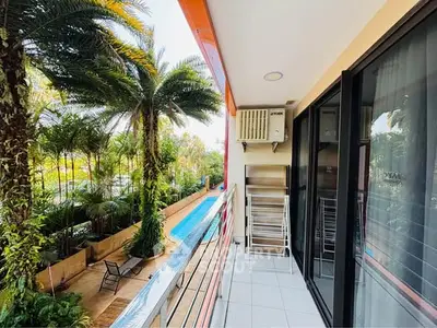 Charming balcony with pool view and lush greenery, perfect for relaxation and outdoor enjoyment.
