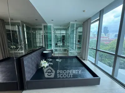 Luxurious modern bedroom with floor-to-ceiling windows and city view, featuring sleek mirrored walls and elegant decor.