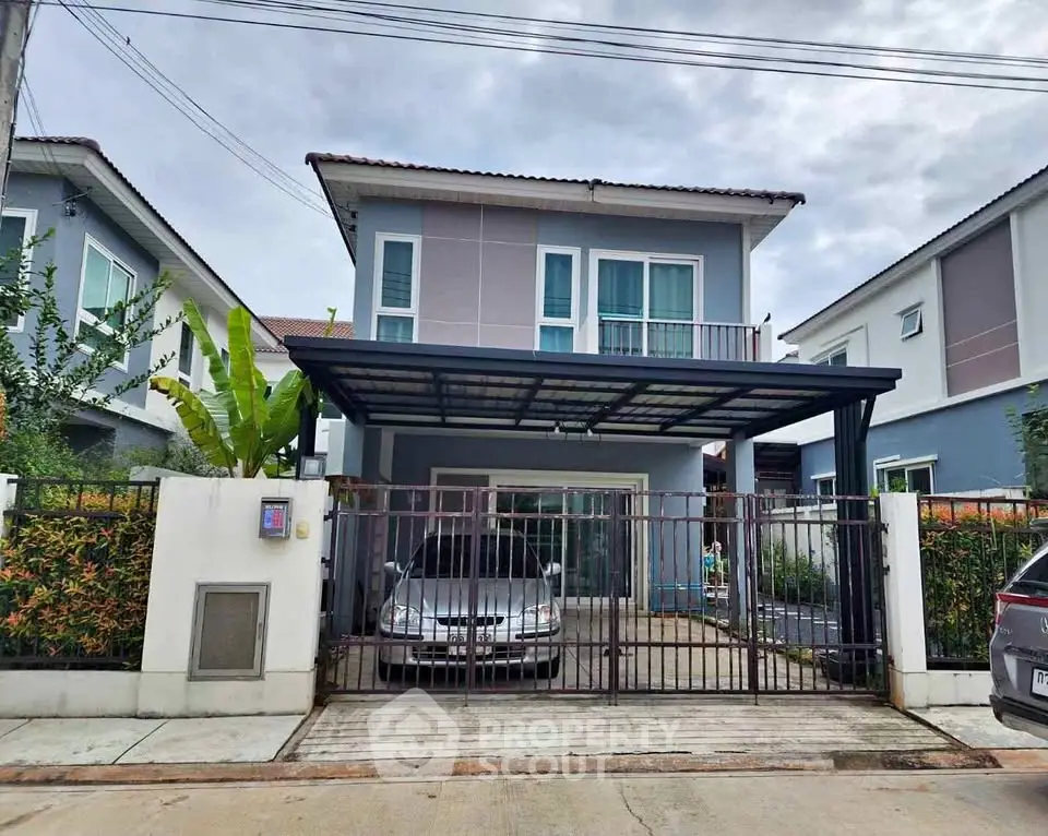 Modern two-story house with carport and gated driveway in suburban neighborhood.