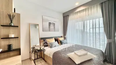 Modern bedroom with stylish decor and large window offering natural light.
