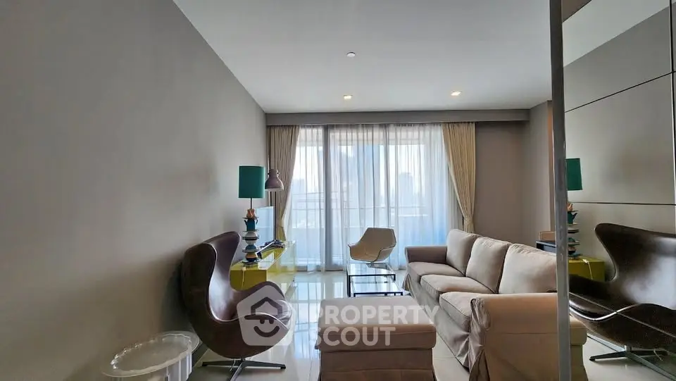 Modern living room with stylish furniture and large window offering city views.