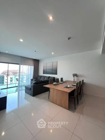 Spacious modern living room with dining area and balcony view