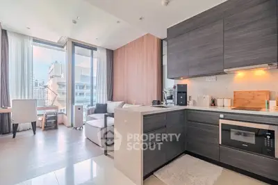 Modern open-layout kitchen and living area with city view, sleek cabinetry, and natural light.