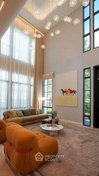 Luxurious high-ceiling living room with modern decor and large windows