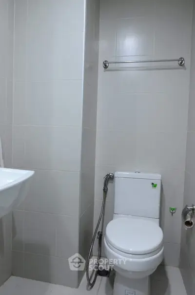 Modern bathroom with sleek white tiles and contemporary fixtures.