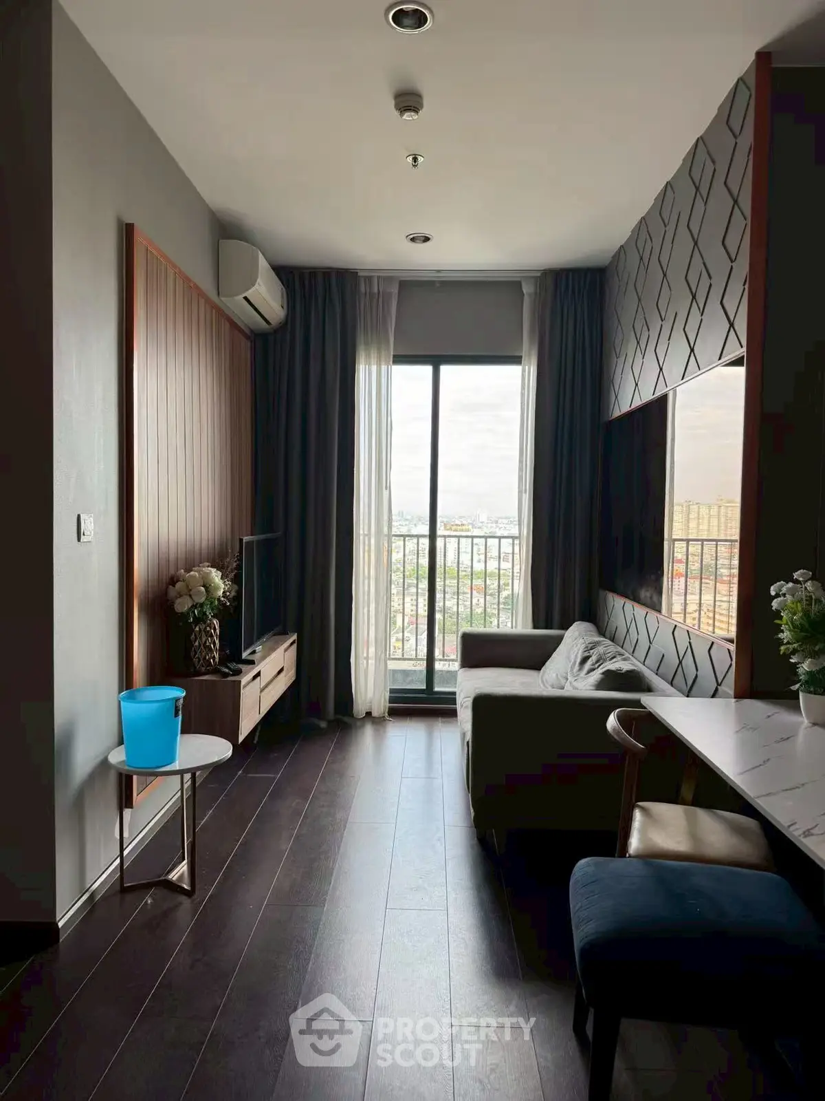 Modern living room with balcony view, stylish decor, and natural light.