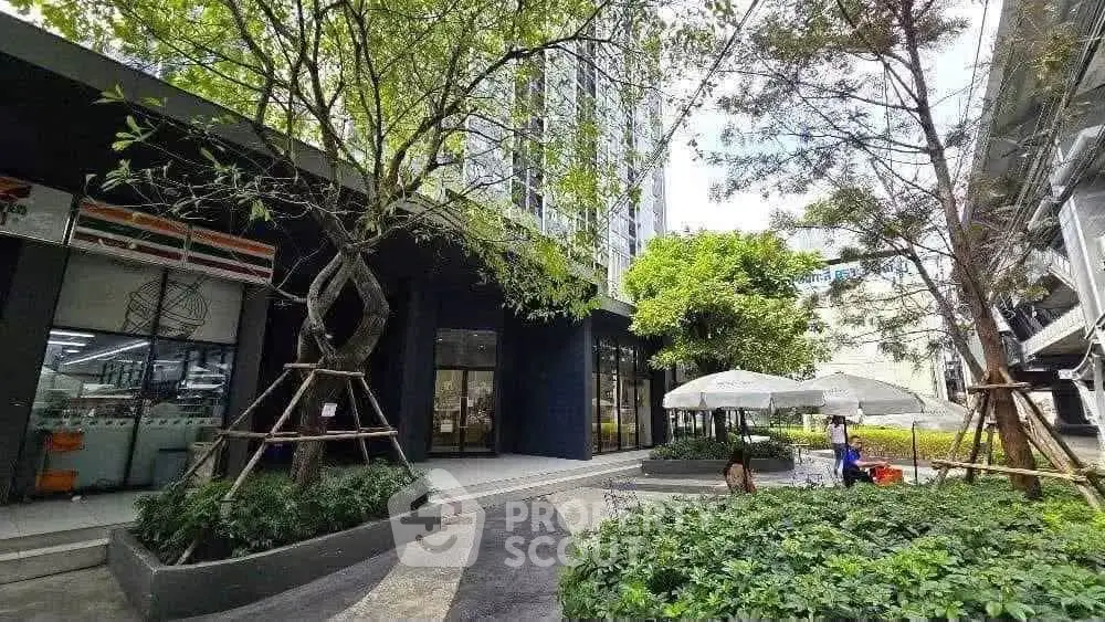 Modern building exterior with lush greenery and outdoor seating area