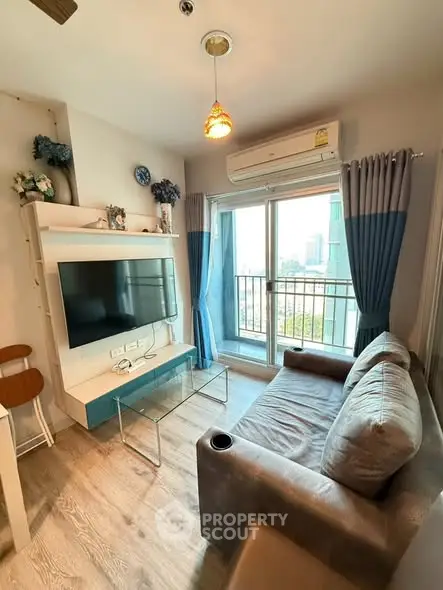 Cozy living room with modern decor and balcony view in a stylish apartment.