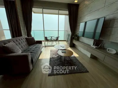 Modern living room with ocean view, stylish furniture, and floor-to-ceiling windows.