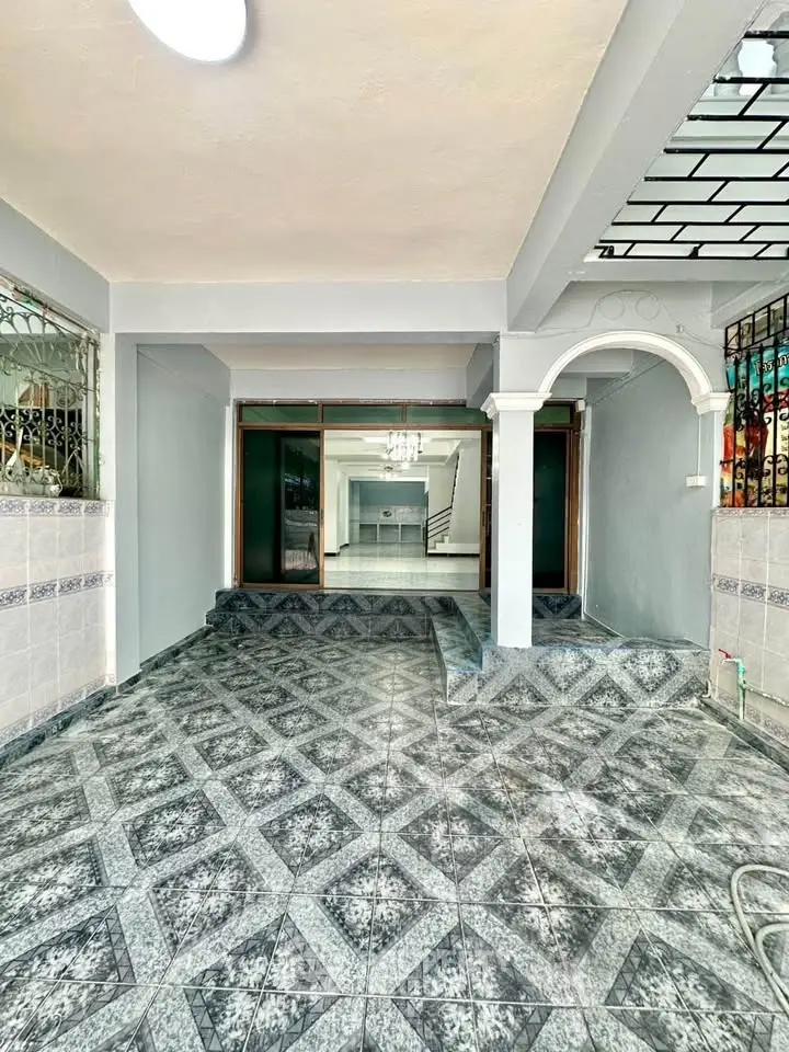 Spacious tiled entrance with elegant archway leading to modern interior
