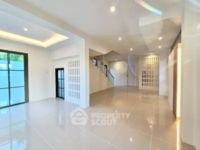 Spacious modern living room with sleek tile flooring and elegant lighting, perfect for contemporary living.