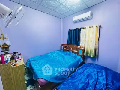 Cozy bedroom with blue bedding, air conditioning, and decorative curtains.