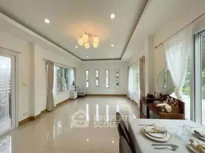 Spacious modern living room with elegant dining area and large windows offering natural light.