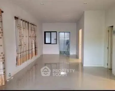Spacious empty room with glossy tiled floor and large windows, ideal for customization.