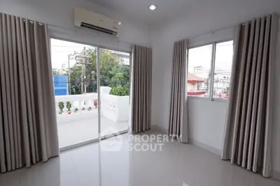 Bright room with large windows and balcony access, featuring modern curtains and air conditioning.