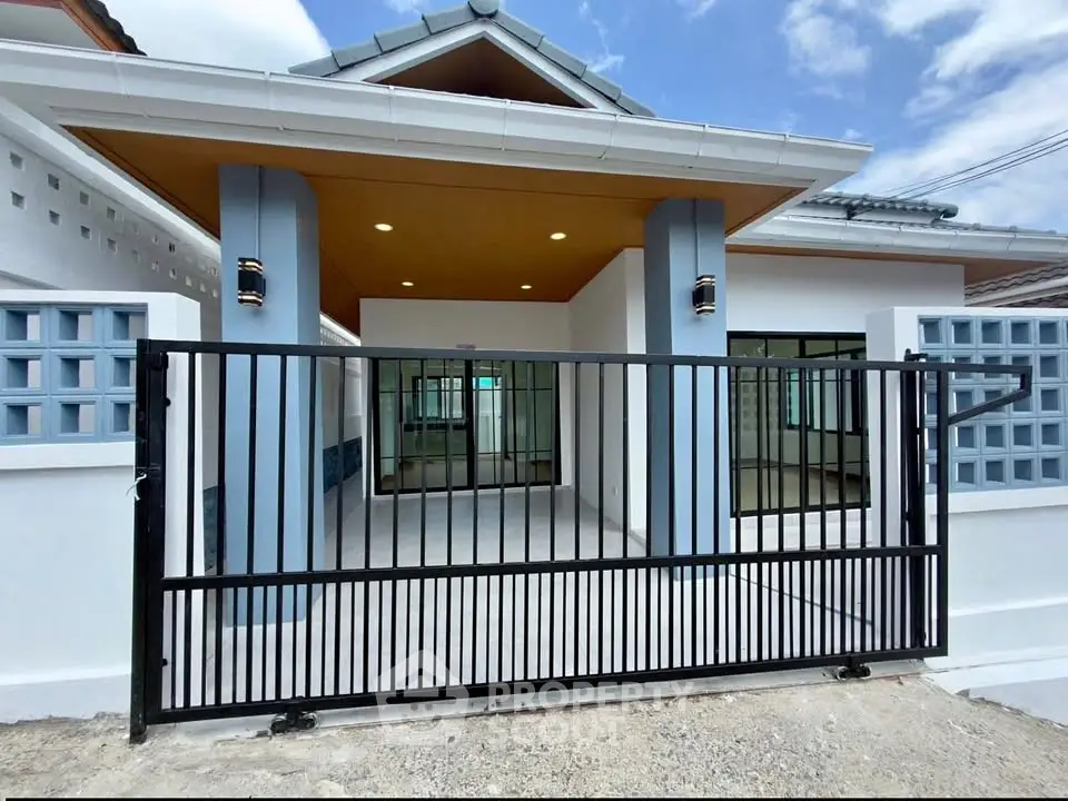 Modern single-story house with gated entrance and stylish exterior design.