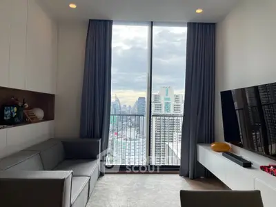 Modern living room with city view, sleek furniture, and large window.