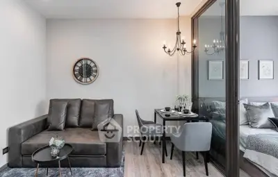 Modern living room with stylish decor and adjacent bedroom in a chic apartment.