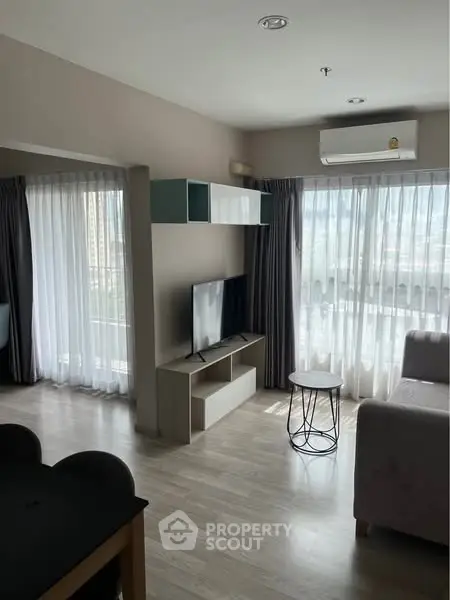 Modern living room with natural light, sleek furniture, and stylish decor.