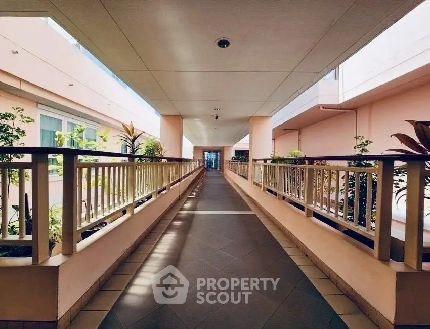 Spacious corridor with natural light and modern design in a residential building.