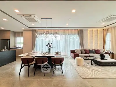 Luxurious open-plan living and dining area with modern decor and ample natural light.