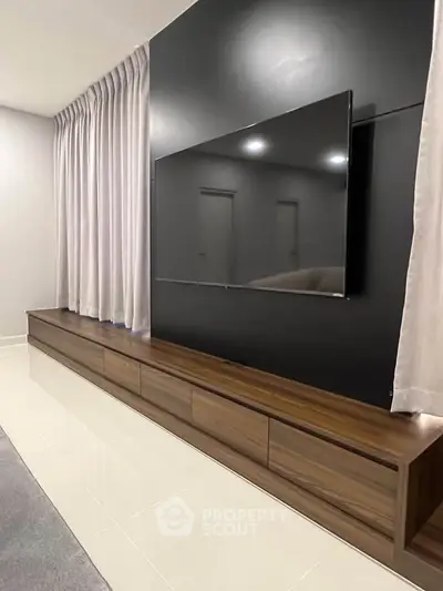 Modern living room with sleek TV setup and elegant curtains
