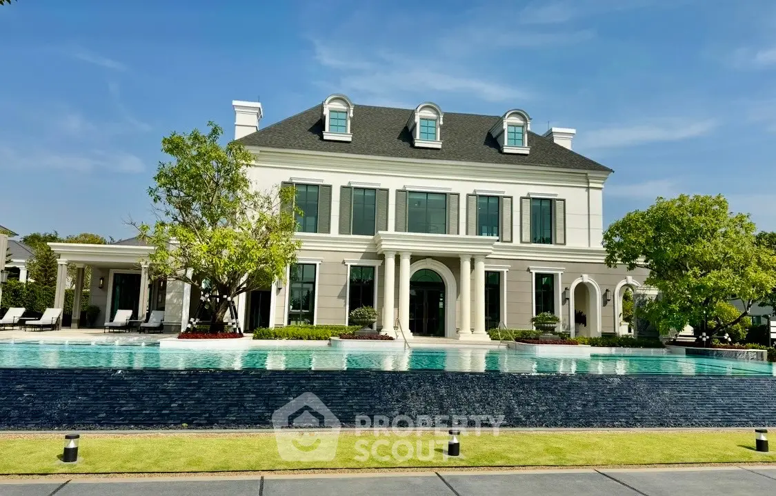 Luxurious mansion with grand architecture and stunning pool in a serene setting.