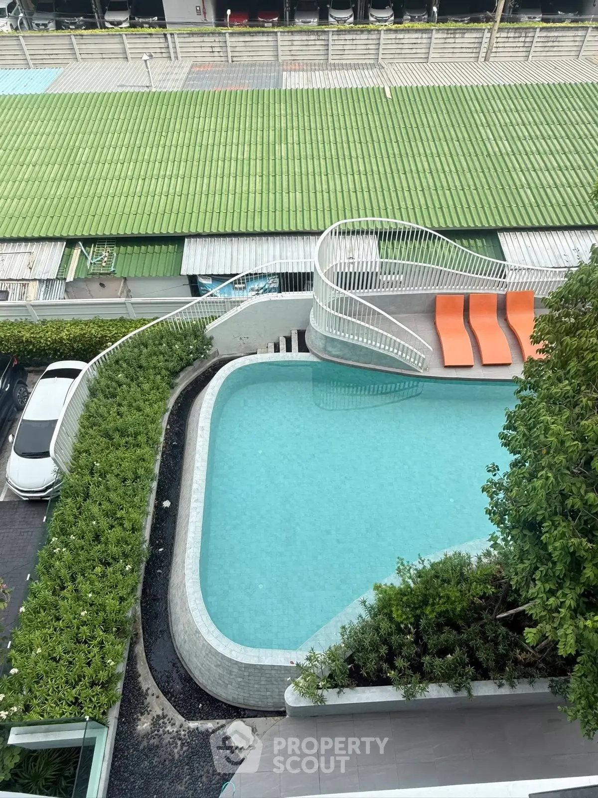 Modern apartment complex with stylish outdoor pool and sun loungers, perfect for relaxation and leisure.